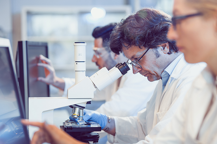 Male scientist using a microscope in a lab setting