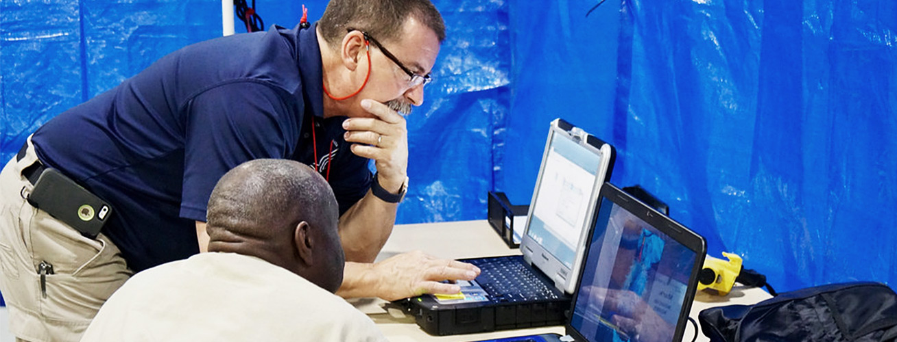 VIC team-member leaning over laptop