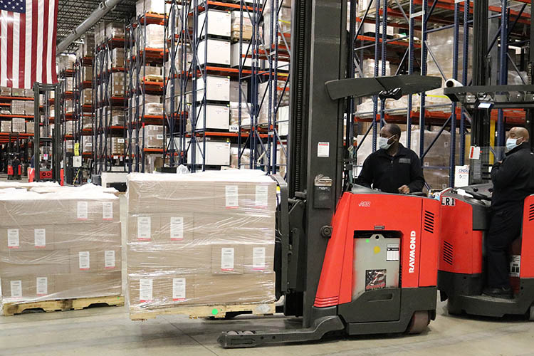 two forklift operators in a warehouse