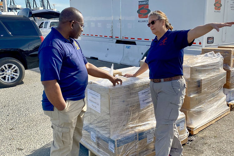 workers standing over a pallet of boxes doing inventory