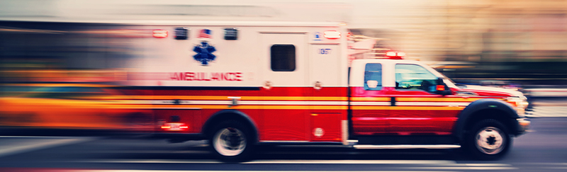 Red ambulance at a city street. Blurred motion. Urgency. Emergency.